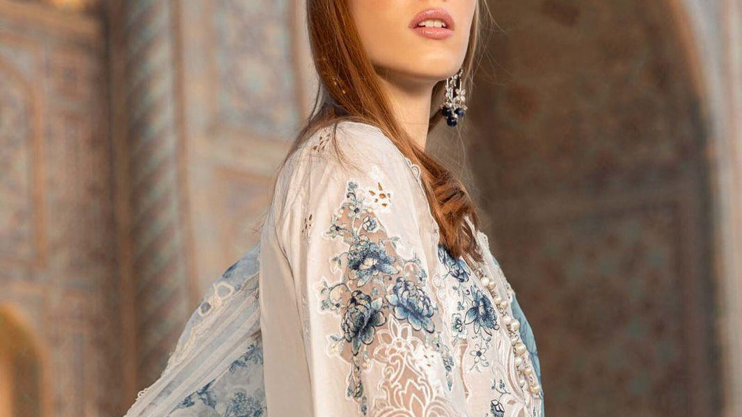 Luxurious white embroidered lawn suit featuring exquisite blue detailing, paired with a stunning digital printed organza dupatta. Maria b